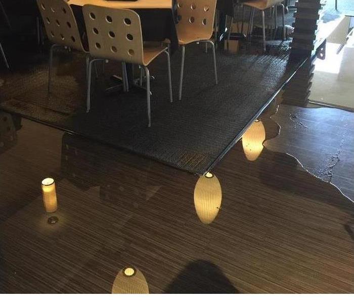 a floor with wood floors, a table and lots of water pooling